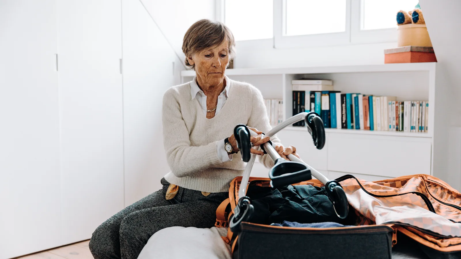 Femme senior préparant sa valise avant un départ en voyage